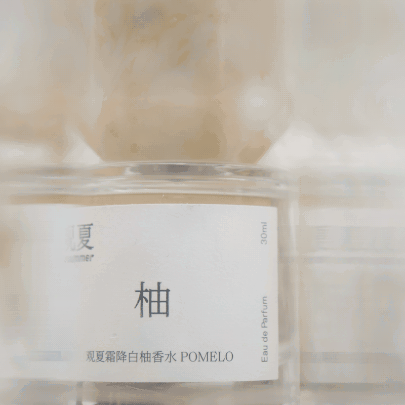 Close-up of To Summer Pomelo Perfume bottle label, highlighting minimalist design and soft lighting.