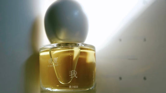 Close-up shot of a tosummer Her Perfume bottle, with soft, gentle light on the bottle, creating a clean and serene aesthetic.