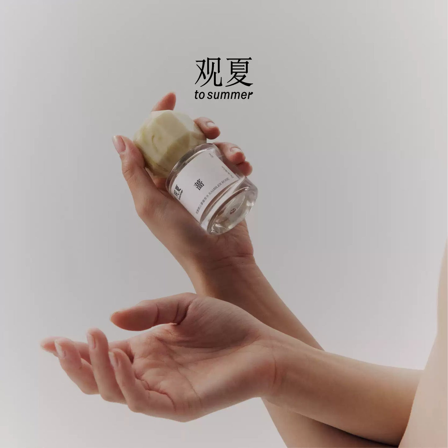 To Summer Rambler Rose perfume held in hands, illustrating a romantic and delicate floral scent.