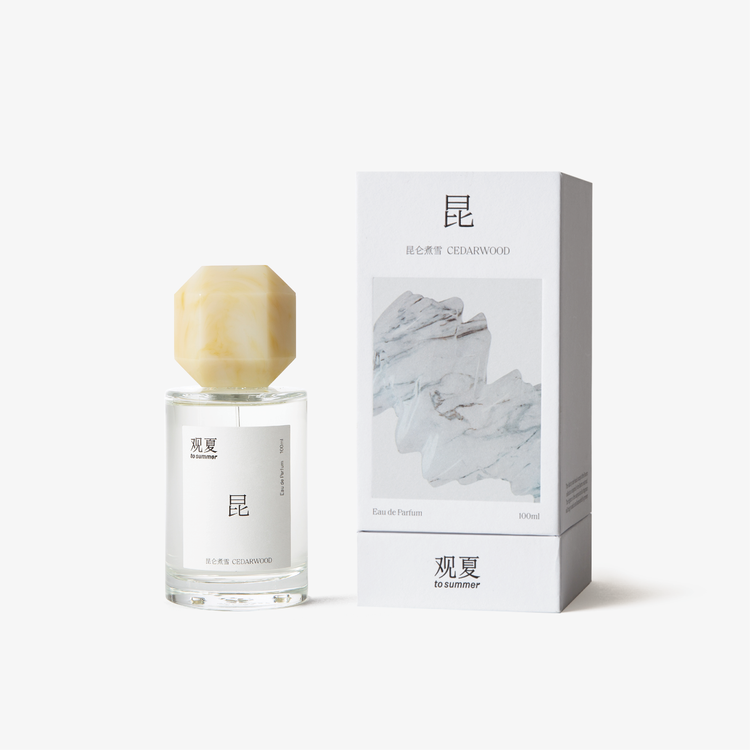 To Summer Cedarwood perfume shown with its white packaging box, which features a gray marble texture design reflecting a calm, natural aesthetic.