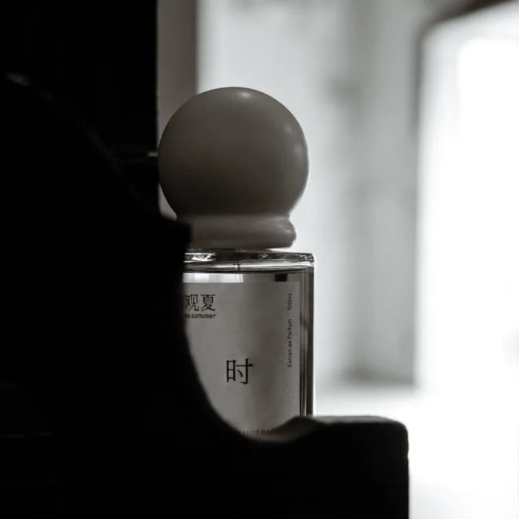 To Summer JAZZBAR perfume bottle hidden in shadows, a luxury unisex fragrance for night wear.