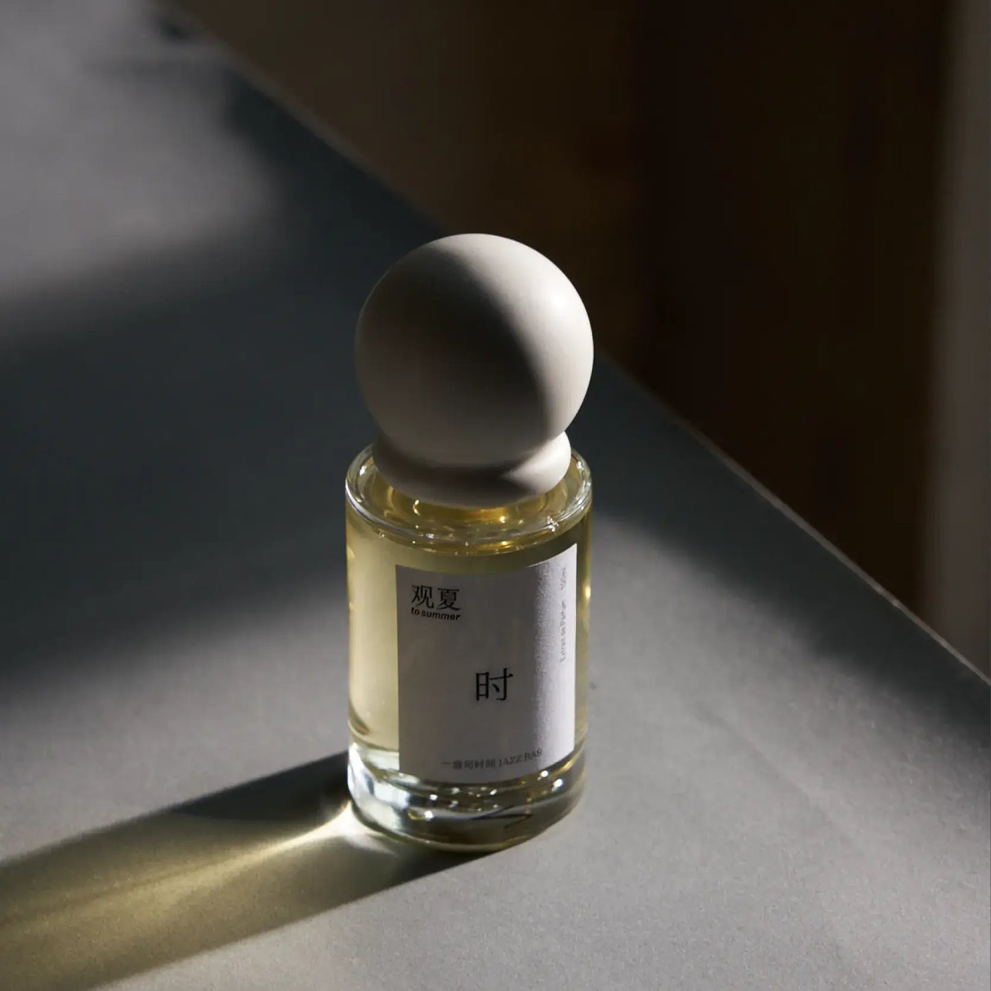 To Summer JAZZBAR perfume in dramatic spotlight, evoking the atmosphere of a vintage jazz club.