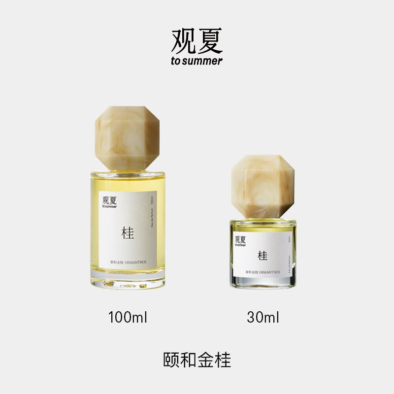 Two bottles of To Summer Osmanthus perfume (100ml & 30ml), perfect gift set showcasing the warm golden hue of the tea-floral scent.