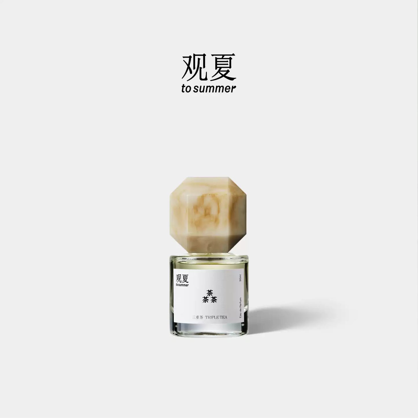 Triple Tea perfume by To Summer, a tea woody fragrance bottle with a beige marble cap on a white background.