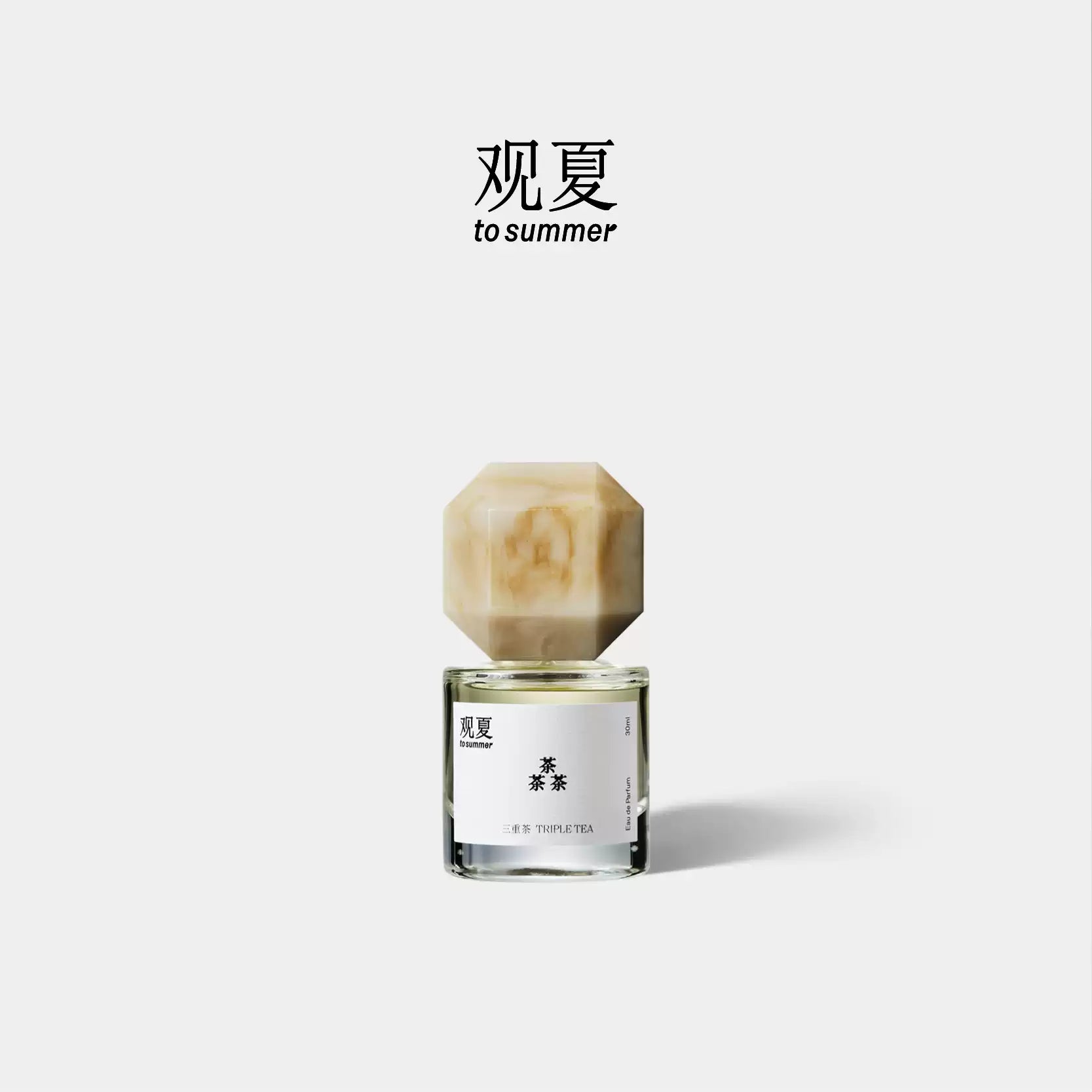 Triple Tea perfume by To Summer, a tea woody fragrance bottle with a beige marble cap on a white background.