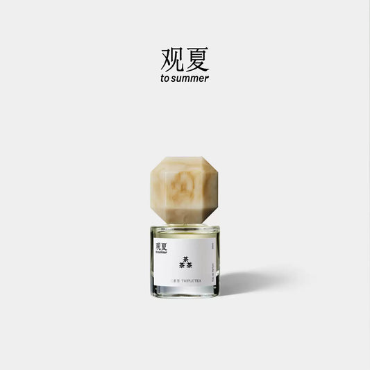 Triple Tea perfume by To Summer, a tea woody fragrance bottle with a beige marble cap on a white background.